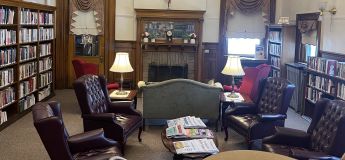 Adams Library's reading room with fireplace and leather chairs